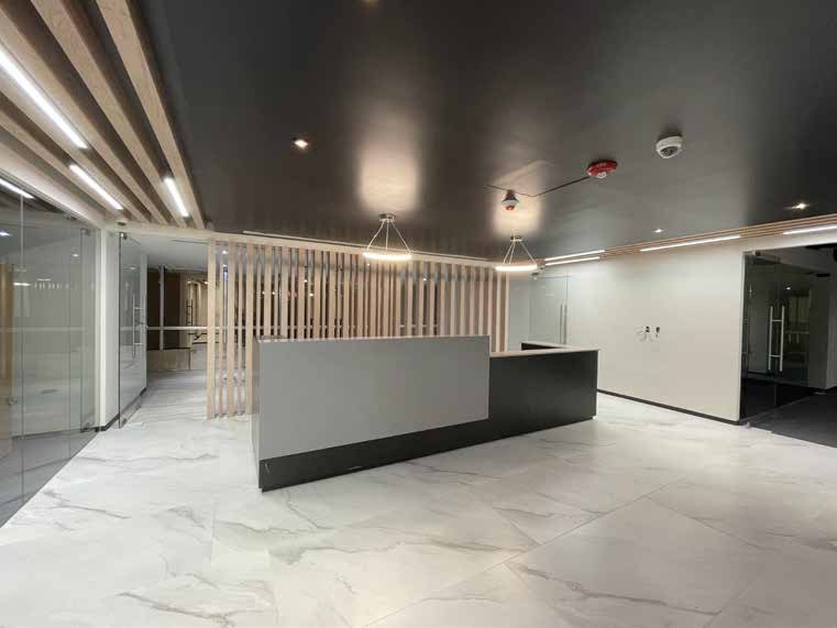 Recepción de oficinas con mostrador y celosía de madera